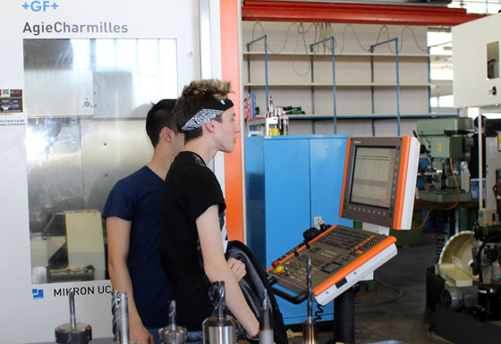 Polymechaniker Lehrlinge beim Studium von CNC-Maschinen